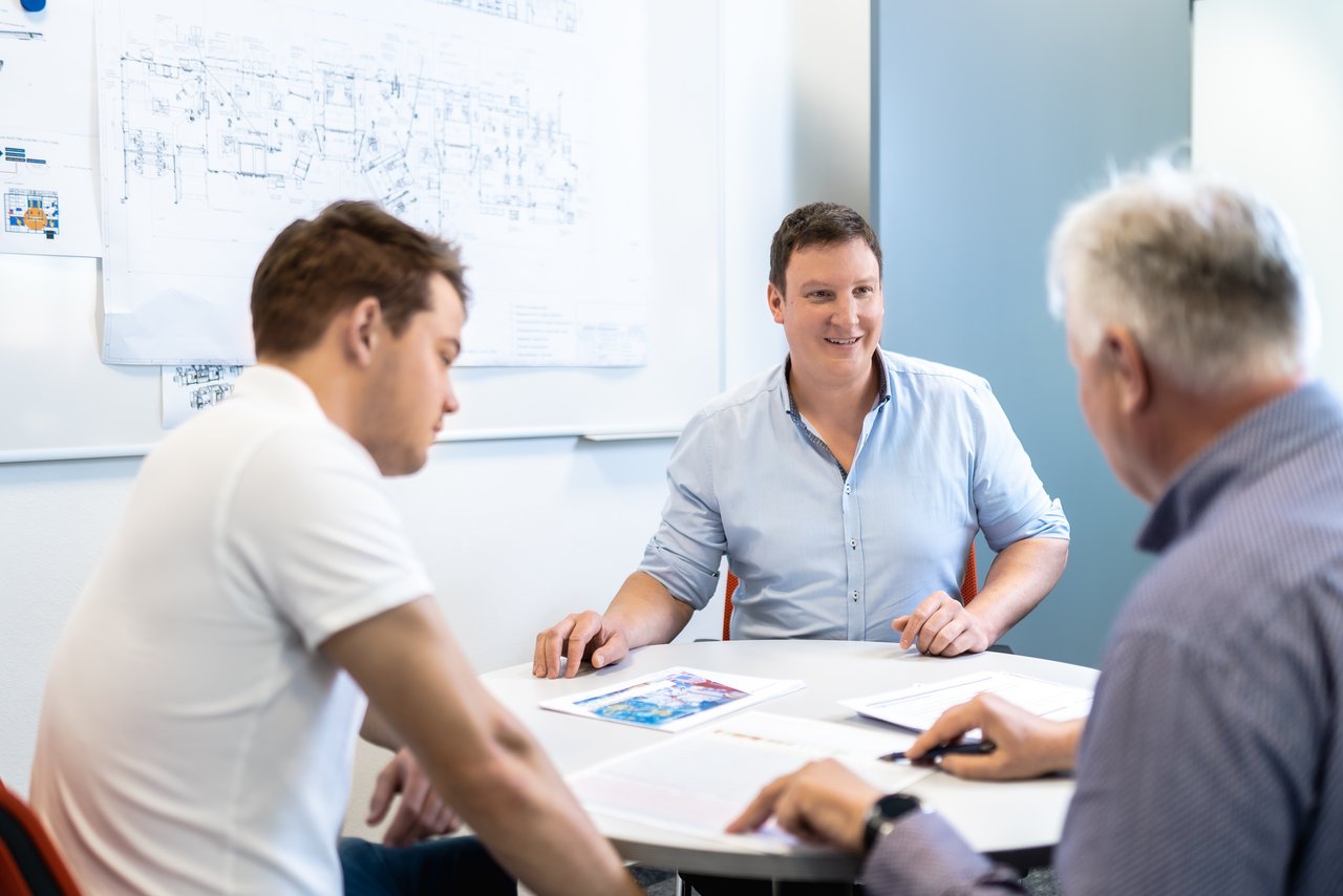 Empowering Drei Mitarbeitende besprechen Konstruktionsthemen bei LEWA Attendorn, Teamarbeit in der technischen Planung