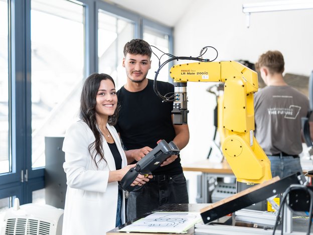 Junge Frau und junger Mann bei Schulung an Roboteranlage, Ausbildung in Automatisierung bei LEWA Attendorn
